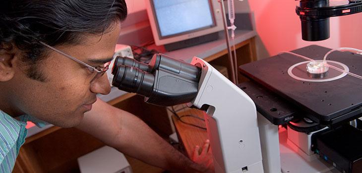 Man looking through microscope